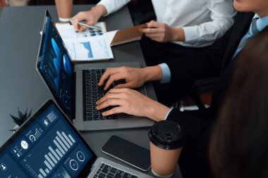 Business team analyze business analytic or business intelligence dashboard on laptop screen show graph and chart with statistic in harmony office. Analyst team meeting researching, planning strategy.