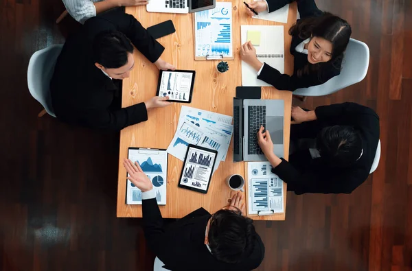 Top-view business team of financial data analysis meeting with business intelligence, report paper and dashboard on laptop for marketing strategy. Business people working together in office of harmony