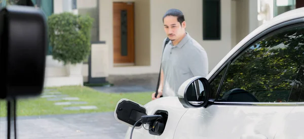 Progressive Asian Man Install Cable Plug His Electric Car Home — Stock fotografie