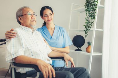 Caring nurse and a contented senior man in a wheel chair at home, nursing house. Medical for elderly senior, home care for pensioners.