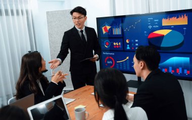 Confidence and asian businessman give presentation on financial analyzed by business intelligence in dashboard report to other people in board room meeting to promote harmony in workplace.