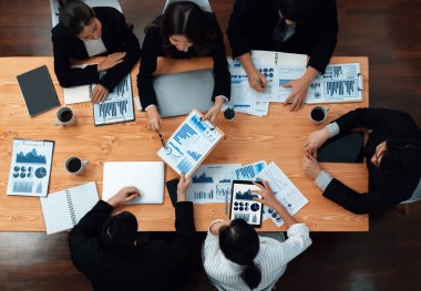 Top-view business team of financial data analysis meeting with business intelligence, report paper and dashboard on laptop for marketing strategy. Business people working together in office of harmony
