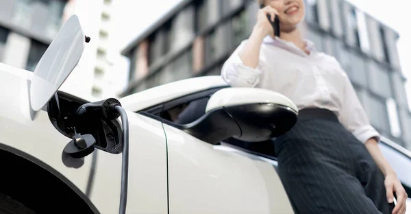 Focus Charging Electric Car Charger Charging Station Blur Businesswoman Talking — Foto de Stock
