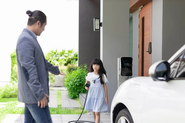 Progressive Father Daughter Plugs Charger Home Charging Station Electric Vehicle — Stok fotoğraf