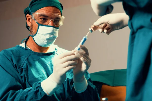 의사는 에서의 수술을 술병에서 주사기를 간호사와 채운다 수술을 완벽하게 의사와 — 스톡 사진