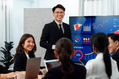 Confidence and asian businessman give presentation on financial analyzed by business intelligence in dashboard report to other people in board room meeting to promote harmony in workplace.