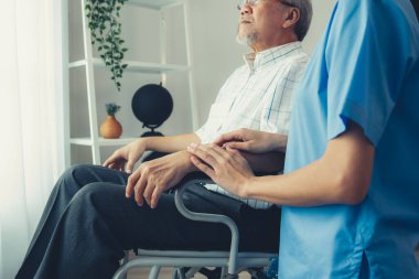 Caring nurse and a contented senior man in a wheel chair at home, nursing house. Medical for elderly senior, home care for pensioners.