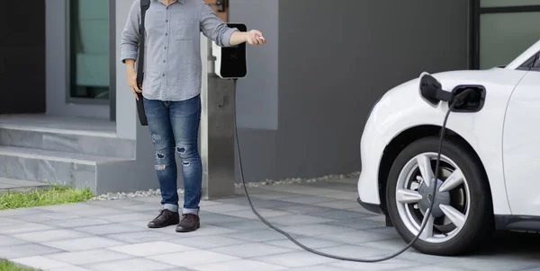 Progressive Asian Man Electric Car Home Charging Station Concept Use — Zdjęcie stockowe