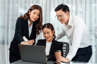 Harmony in office concept as business people analyzing dashboard paper together in workplace. Young colleagues give ideas at manager desk for discussion or strategy planning about project.
