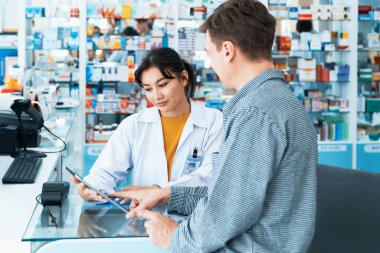 Kalifiye eczanedeki ödeme terminali ile kredi kartıyla ödeme. Elektrik parasının modern finansal ödemesi. Eczaneden eczacının reçetesiyle beyaz müşteriler ilaç satın alıyor..