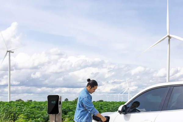 Postępowy Człowiek Swoim Samochodem Elektrycznym Samochód Ładuje Energię Stacji Ładowania — Zdjęcie stockowe