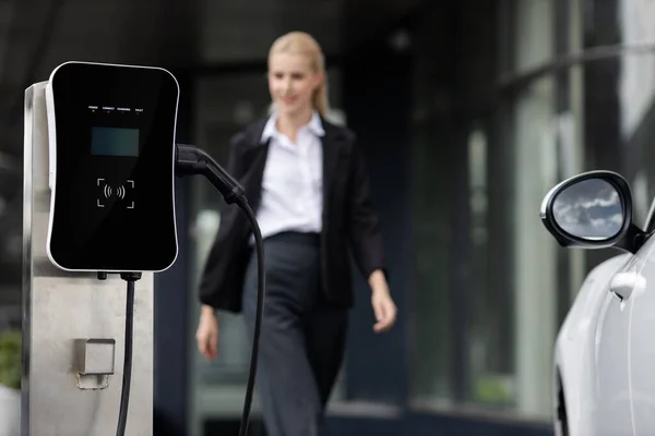 Focus Public Charging Station Electric Car Blurred Progressive Businesswoman Walking —  Fotos de Stock