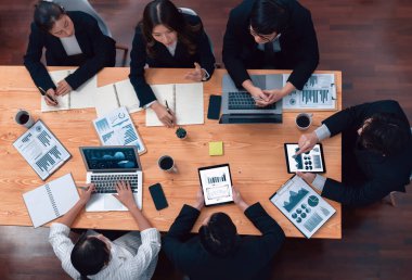 Top-view business team of financial data analysis meeting with business intelligence, report paper and dashboard on laptop for marketing strategy. Business people working together in office of harmony