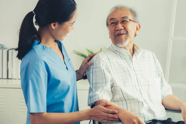 Happy Positive Asian Nurse Giving Support Touching Contented Senior Man — Photo