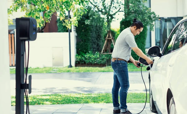 Progressive Asian Man Install Cable Plug His Electric Car Home — Foto Stock