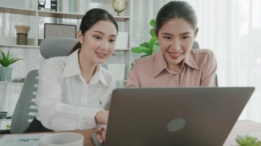 Hevesli ofis çalışanları ofis işyerindeki başarılarını kutluyorlar. Bilgisayarlı bir masada iş birliği yapan ve başarı elde eden meslektaşlar. İki iş kadını işlerinden memnun..