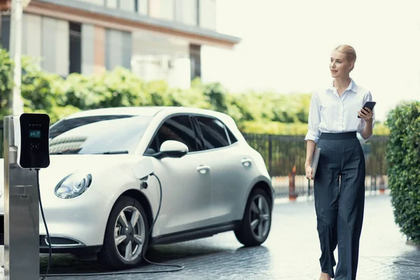 Businesswoman Using Tablet Walking While Recharging Her Electric Vehicle Charging — Stockfoto