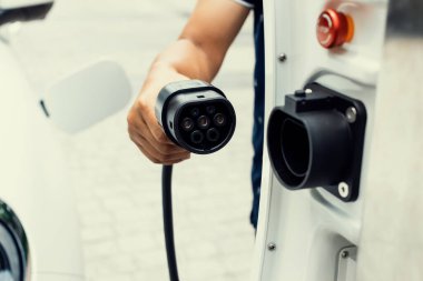 Gelişen el kavramı, evdeki elektrikli aracın bataryasına emisyonsuz güç bağlantısı sağlar. Elektrikli araç elektrik istasyonundan EV araba aküsüne kabloyla şarj oluyor.
