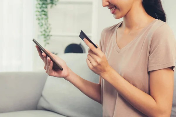 Contented Young Woman Eagerly Makes Online Purchase Using Her Smartphone — Stockfoto