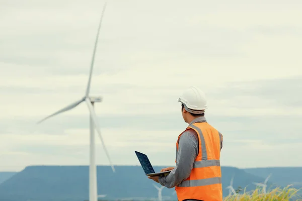 stock image Engineer working on a wind farm atop a hill or mountain in the rural. Progressive ideal for the future production of renewable, sustainable energy. Energy generation from wind turbine.