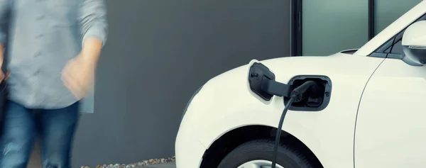 Фокус Електричний Автомобіль Заряджається Домашній Зарядній Станції Розмитим Прогресивним Чоловіком — стокове фото