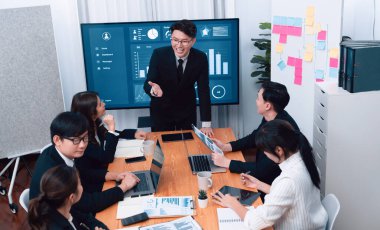 Confidence and asian businessman give presentation on financial analyzed by business intelligence in dashboard report to other people in board room meeting to promote harmony in workplace.