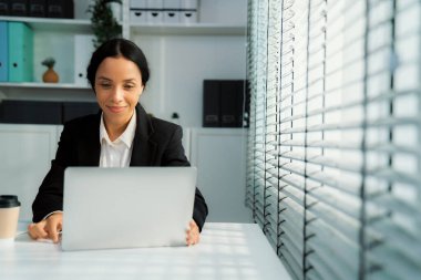 This photo depicts a young African American and competent woman at her workplace. A female employee in her office at work.