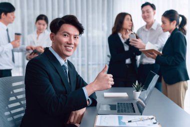 Portrait of focus young successful confident male manager, executive wearing business wear in harmony office arm crossed with blurred meeting background of colleagues, office worker.
