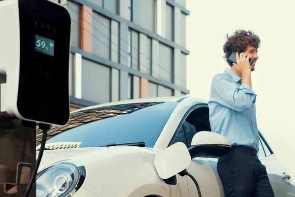 Progressive Businessman Talking Phone Leaning Electric Car Recharging Public Charging — 图库照片