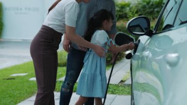 Elektrikli araç şarj istasyonu olan, sağlıklı ve temiz bir çevreyi teşvik eden yenilikçi bir aile kavramı. Sürdürülebilir, temiz enerji teknolojisiyle çalışan elektrikli araç..