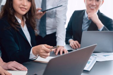 Harmony in office concept as business people analyzing dashboard paper together in workplace. Young colleagues give ideas at manager desk for discussion or strategy planning about project.