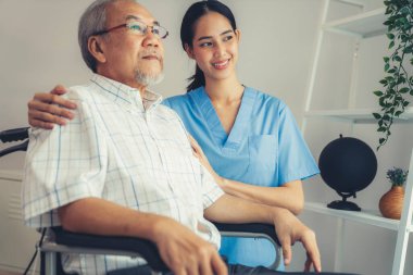 Caring nurse and a contented senior man in a wheel chair at home, nursing house. Medical for elderly patient, home care for pensioners.