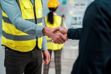 After concluding the meeting, competent investor shakes hands with engineer. Concept of the agreement between engineers and investors.