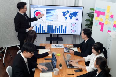 Confidence and asian businessman give presentation on financial analyzed by business intelligence in dashboard report to other people in board room meeting to promote harmony in workplace.