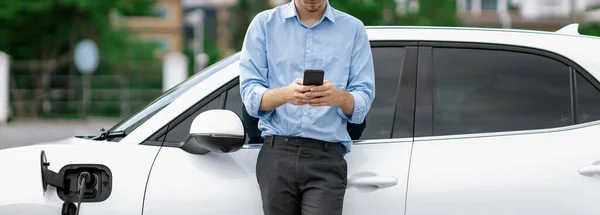 Progressive Businessman Talking Phone Leaning Electric Car Recharging Public Charging — Foto Stock