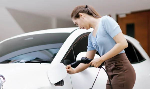 Progressive Woman Install Cable Plug Her Electric Car Home Charging — Zdjęcie stockowe