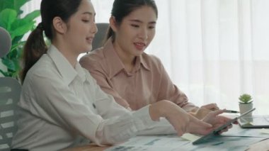Ofis çalışma alanında birlikte çalışan iki genç hevesli iş kadını. Genç meslektaşlar tartışırken ve dizüstü bilgisayar kullanırken. Modern ofis çalışanları masada birlikte oturuyorlar..