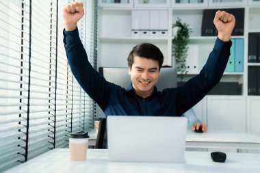 Young male employee receives a promotion, good news or finished his task and overjoyed for being a competent worker. Idea of promotion in career, reward for working hard worker.