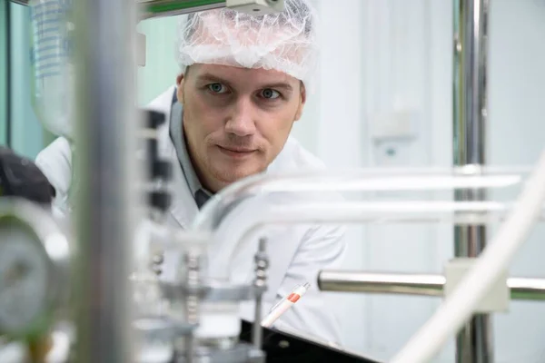 stock image Portrait of a scientist, apothecary extracting cannabis oil with a glass tube for liquid flow in a laboratory. Cannabis extraction for alternative medical treatment concept.