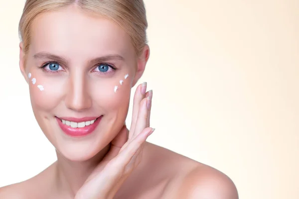 stock image Personable beautiful perfect clean skin soft makeup woman finger applying moisturizer cream on her face under contour eye for anti aging wrinkle. Facial skin rejuvenation in isolated background.