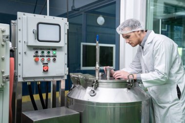 Bir bilim adamının portresi, eczacı laboratuarda bilimsel ekipman kullanarak kenevir yağı çıkarıyor. Alternatif tıbbi tedavi için esrar çıkarma kavramı