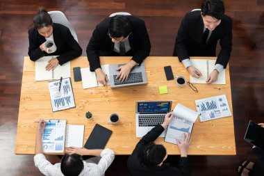 Top-view business team of financial data analysis meeting with business intelligence, report paper and dashboard on laptop for marketing strategy. Business people working together in office of harmony