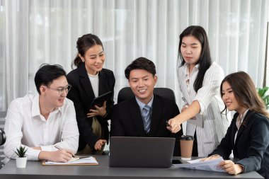 Harmony in office concept as business people analyzing dashboard paper together in workplace. Young colleagues give ideas at manager desk for discussion or strategy planning about project.