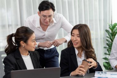 Harmony in office concept as business people analyzing dashboard paper together in workplace. Young colleagues give ideas at manager desk for discussion or strategy planning about project.