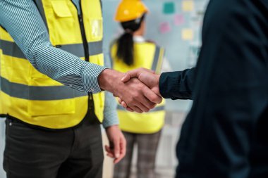 After concluding the meeting, competent investor shakes hands with engineer. Concept of the agreement between engineers and investors.