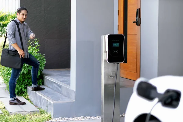 Progressive Asian Man Electric Car Home Charging Station Concept Use — Foto Stock