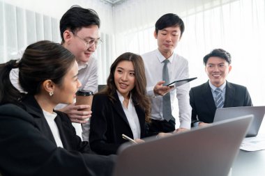 Harmony in office concept as business people analyzing dashboard paper together in workplace. Young colleagues give ideas at manager desk for discussion or strategy planning about project.