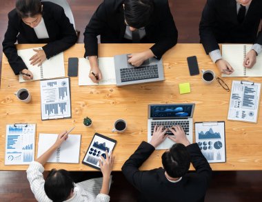 Top-view business team of financial data analysis meeting with business intelligence, report paper and dashboard on laptop for marketing strategy. Business people working together in office of harmony