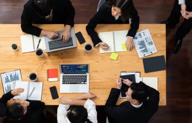 Top view manager or office worker give presentation in harmony conference room to business colleague, BI data dashboard on screen and pile of financial analyzed data reports on meeting table.