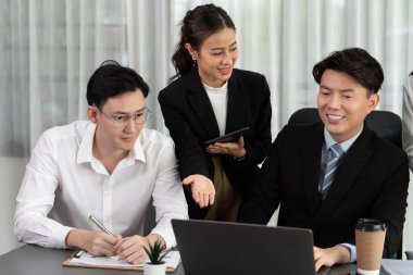 Harmony in office concept as business people analyzing dashboard paper together in workplace. Young colleagues give ideas at manager desk for discussion or strategy planning about project.